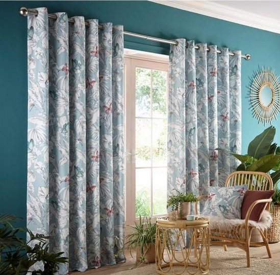 Light blue floral curtains against teak blue walls