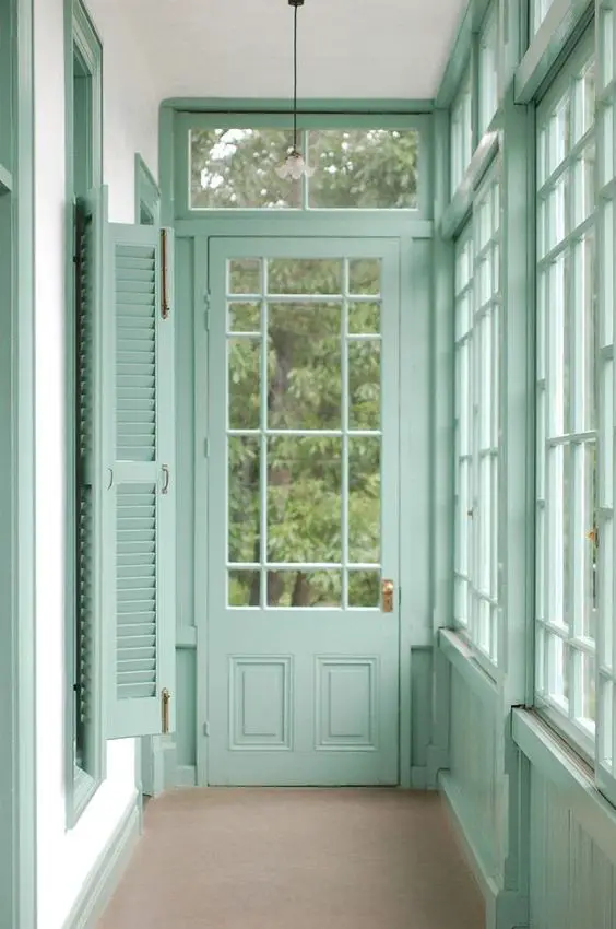 An interior hallway with the woodwork painted in eau de nil