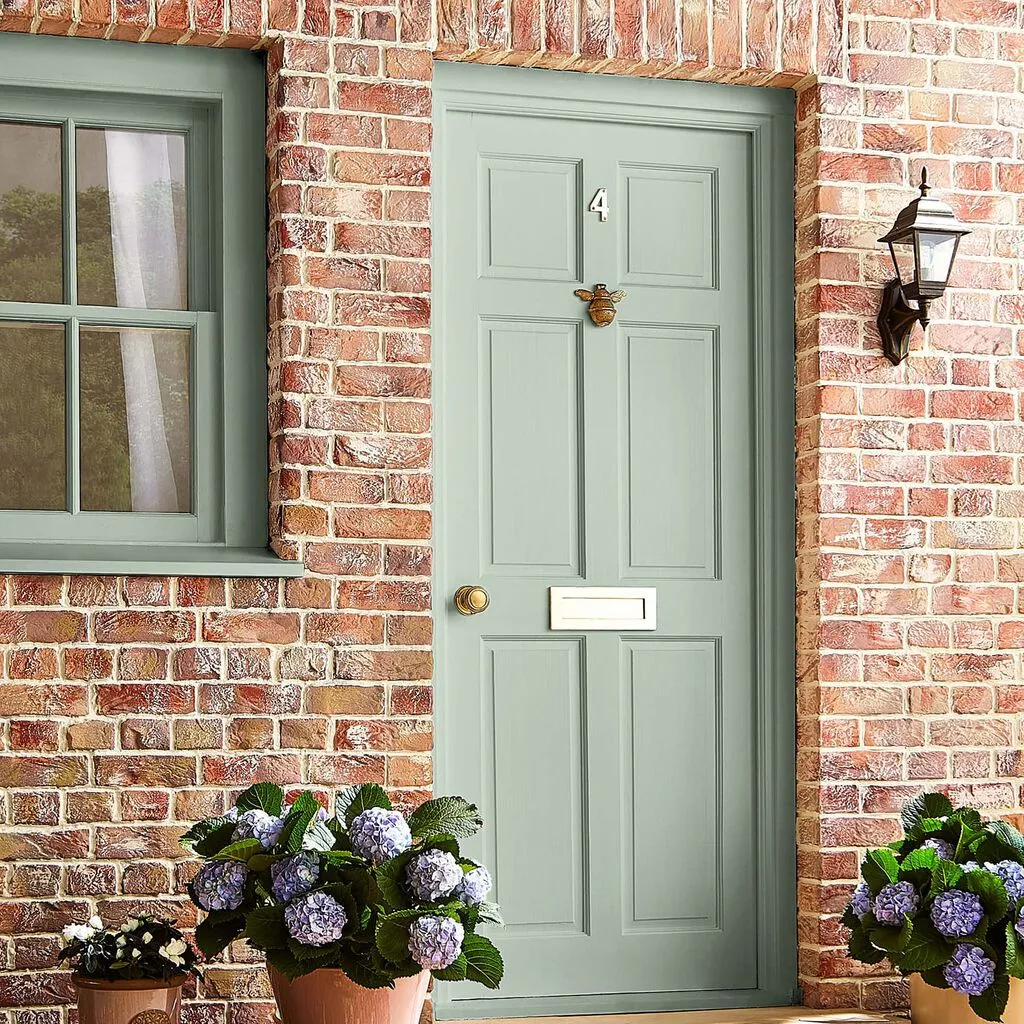 Brick house with a front wood painted in eau de nil