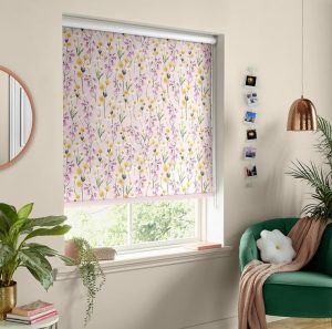 Pink floral collar blind in a modern bedroom with a green velvet armchair