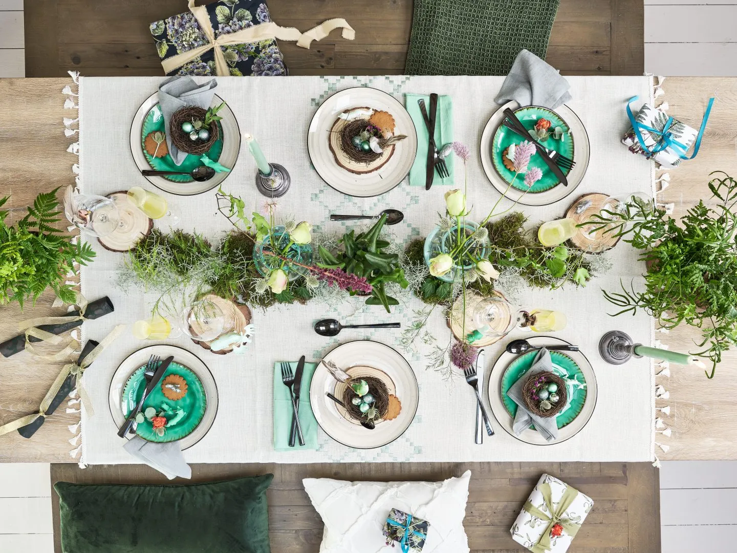 Table decorated for a Christmas lunch with natural leaves and flowers.