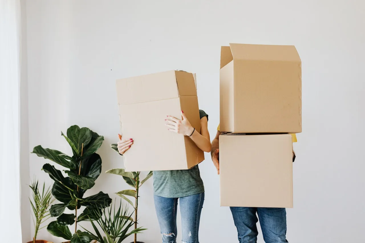 Image of a couple carrying large packing boxes