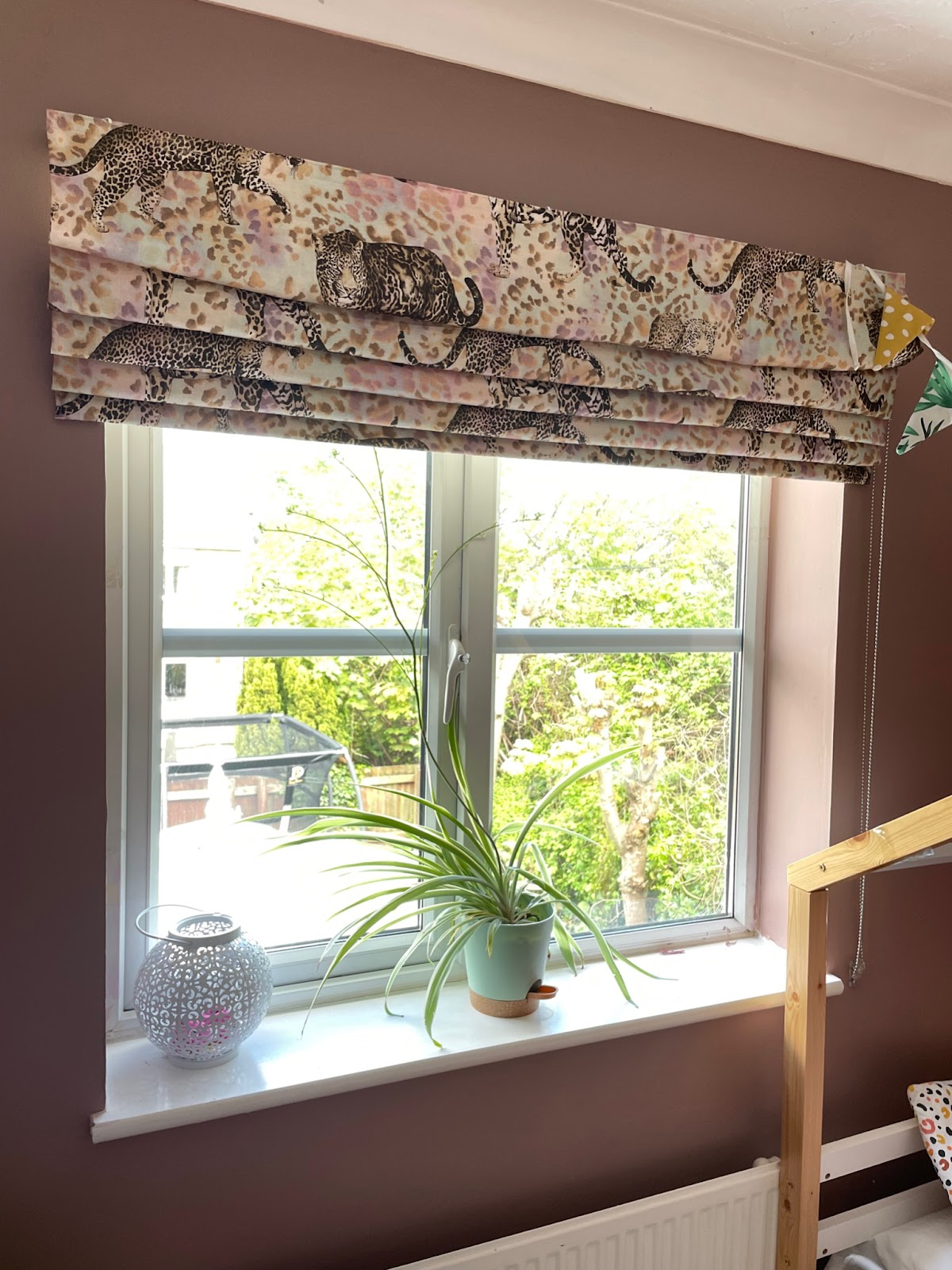 leopard print roman blinds against sulking room pink walls