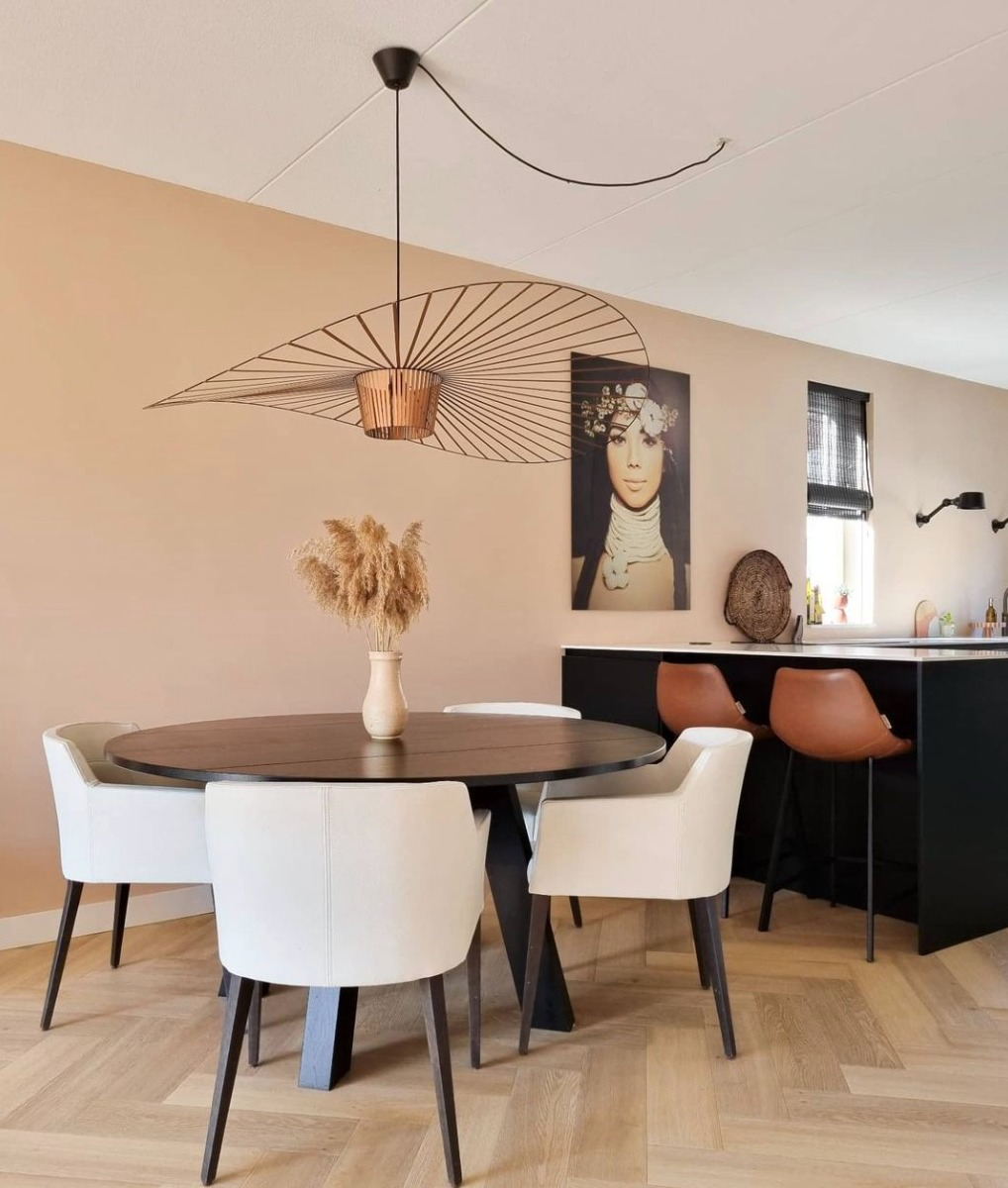 Kitchen dining room with plaster Pink walls and black furniture and accessories.