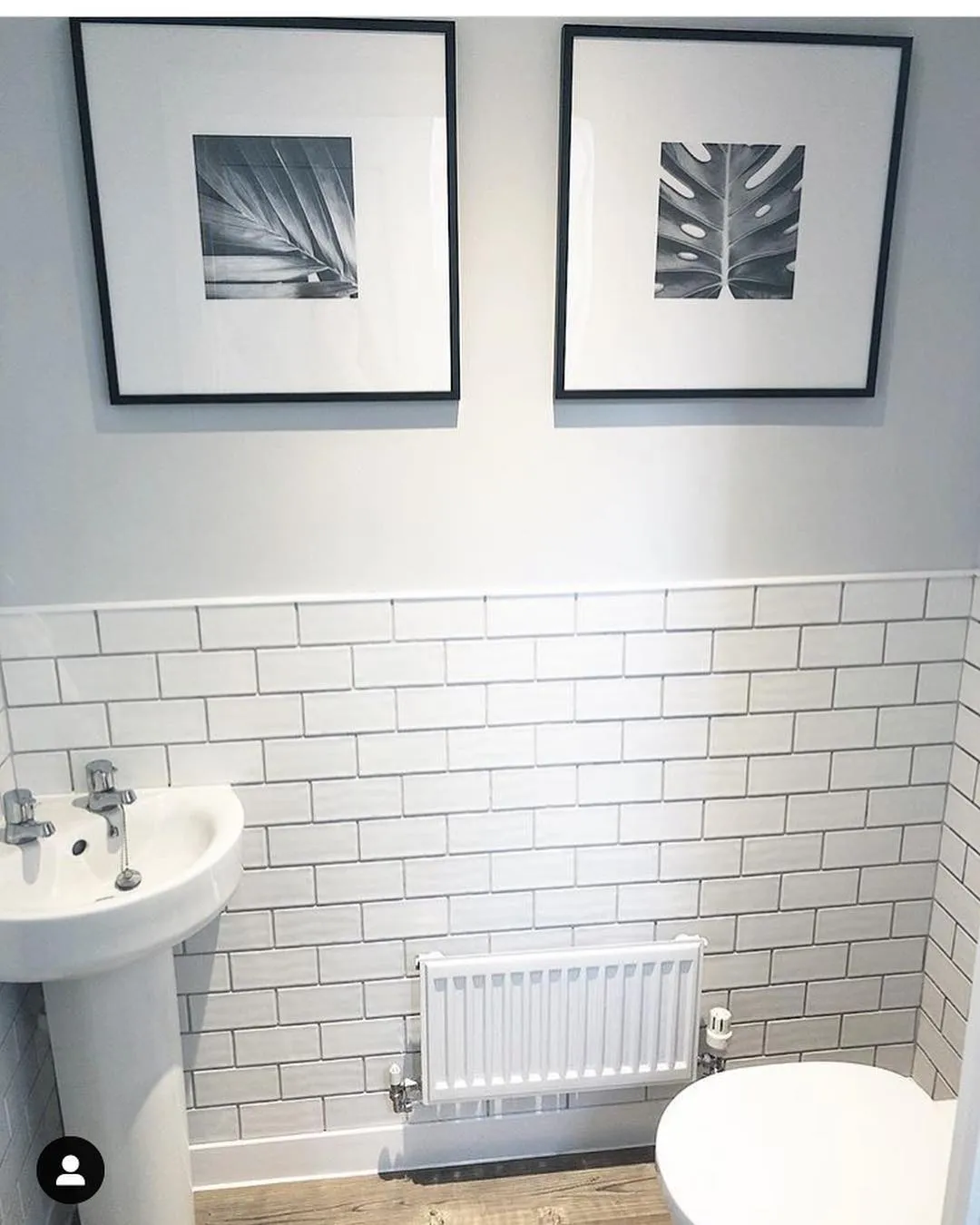 A modern downstairs loo with zellige subway tiles on the bottom half of the walls, and Farrow and Ball Blackened on the top half