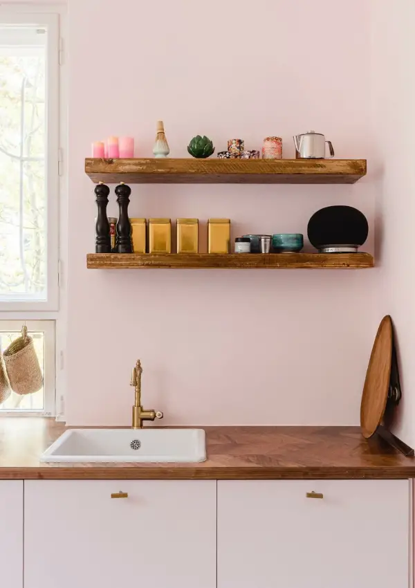 A modern kitchen with a butler sink and wooden worktop painted in Middleton Pink by Farrow and Ball