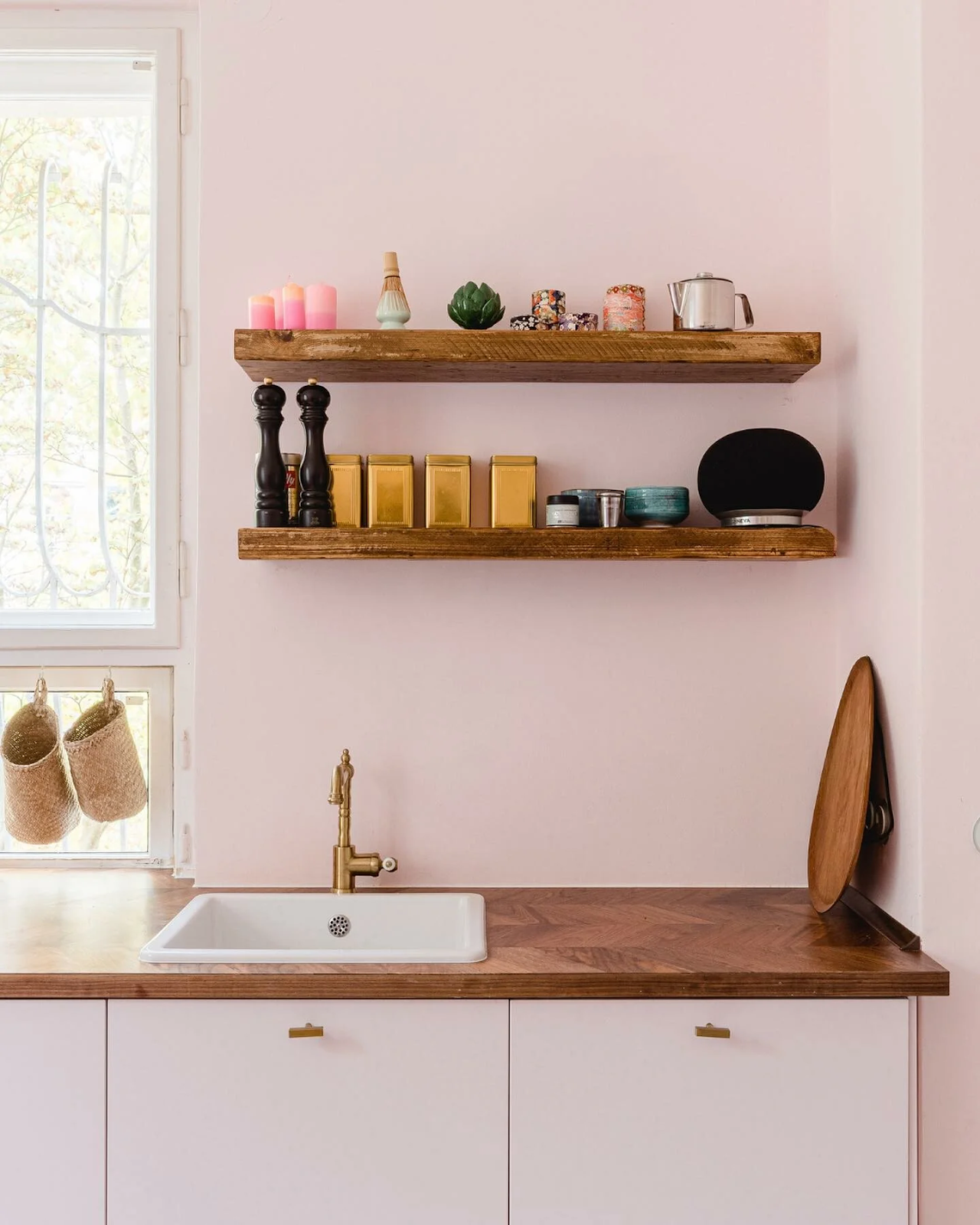 A modern kitchen with a butler sink and wooden worktop painted in Middleton Pink by Farrow and Ball