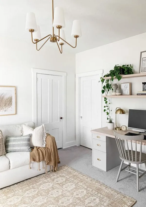 A spare bedroom with a neutral colour scheme. A sofa bed on the right and a desk on the left.