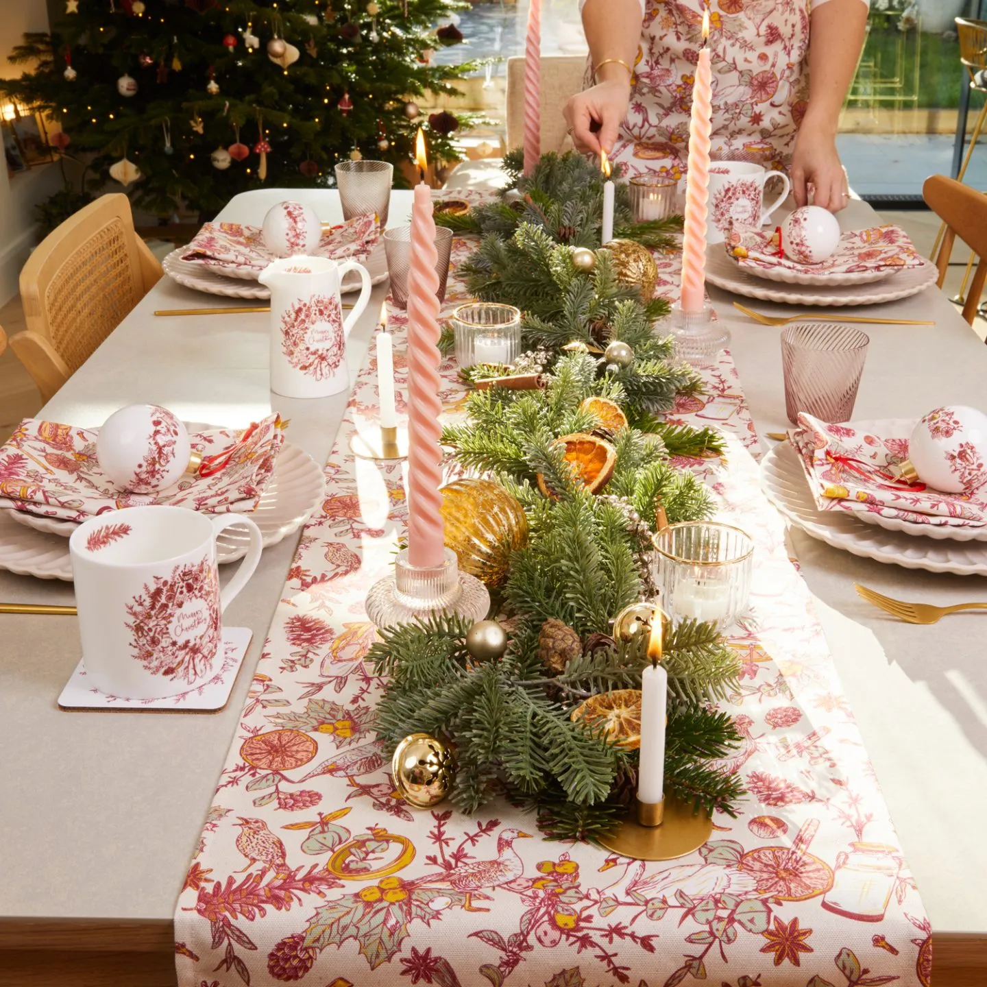 A christmas table decorated in a red and white colour scheme with a red and white patterned table runner.