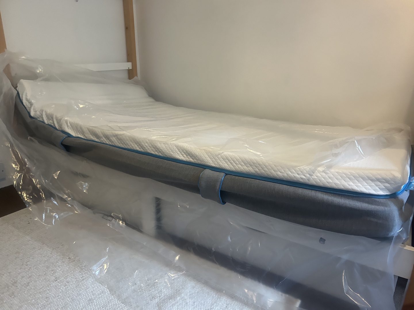 A freshly unboxed Simba Mattress before it has regained its original shape, on a bed frame.